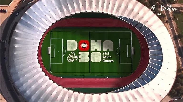 ایک فٹ بال اسٹیڈیم کا فضائی منظر جس میں "DOHA 30 21st Asian Games" کا لوگو میدان پر ہے۔